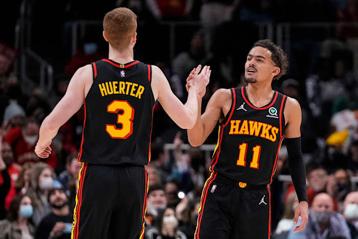 Hawks guards Kevin Huerter and Trae Young celebrate a play.